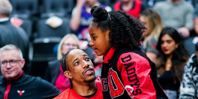 DeMar DeRozan, de los Chicago Bulls, abraza a su hija antes de un partido contra los Toronto Raptors durante el Torneo Play 2023 el 12 de abril de 2023 en el Scotiabank Arena de Toronto. 