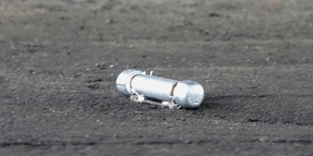 A suspicious object is seen on the ground where a suspect was arrested before Japanese Prime Minister Fumio Kishida was to begin his speech, at the Saikazaki port in Wakayama prefecture, western Japan, Saturday, April 15, 2023.