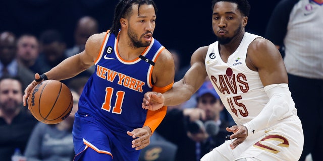 New York Knicks guard Jalen Brunson drives against Cavaliers guard Donovan Mitchell on Friday, March 31, 2023, in Cleveland.