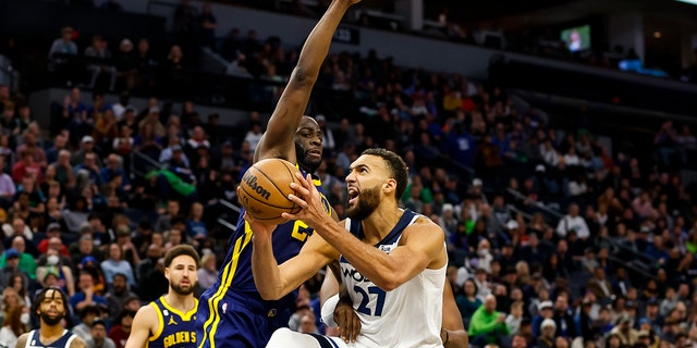 Rudy Gobert (27) of the Minnesota Timberwolves drives to the basket against Draymond Green (23) of the Golden State Warriors in the fourth quarter at Target Center Nov. 27, 2022, in Minneapolis.