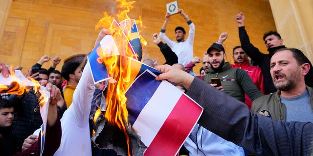 Scores of angry protesters burn the Swedish and Netherlands flags after Friday prayers outside Mohammad al-Amin Mosque to denounce the recent desecration of Islam's holy book by a far-right activists in the European countries in downtown Beirut, Lebanon, on Jan. 27, 2023.