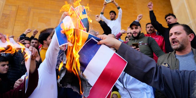 Scores of angry protesters burn the Swedish and Netherlands flags after Friday prayers outside Mohammad al-Amin Mosque to denounce the recent desecration of Islam's holy book by a far-right activists in the European countries in downtown Beirut, Lebanon, on Jan. 27, 2023.