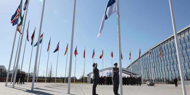 Military personnel raise the flag of Finland during a ceremony on the sidelines of a foreign ministers meeting at NATO headquarters in Brussels.
