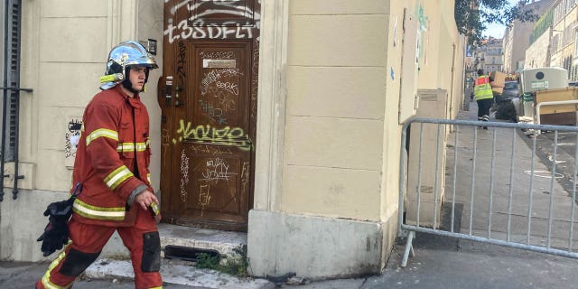 A firefighter walks near the scene where a building collapsed, in Marseille, southern France, on April 10, 2023.