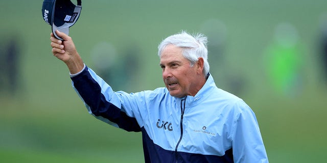 Fred Couples waves as he walks off the 18th green during the completion of the weather-delayed second round of the Masters Tournament at Augusta National Golf Club on April 8, 2023.