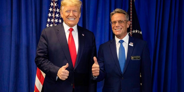 Presiden Donald Trump berpose dengan Perwakilan negara bagian Fred Doucette menjelang rapat umum di Manchester, New Hampshire, pada 11 Februari 2020.