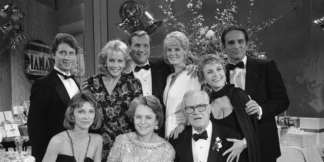 A 1986 cast photo from "As the World Turns" showing, seated from the left: Elizabeth Hubbard (as Lucinda Walsh), Helen Wagner (as Nancy Hughes), Don MacLaughlin (as Chris Hughes) directly behind him: Rosemary Prinz (as Penny Hughes) in rear: Christian LeBlanc (as Kirk McColl), Kim Johnston Ulrich (as Diana McColl), Jay Acovone (as Del Brackett), and Vicky Dawson (as Dee Stewart).