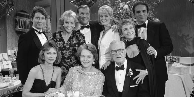 A 1986 cast photo from "As the World Turns" showing, seated from the left: Elizabeth Hubbard (as Lucinda Walsh), Helen Wagner (as Nancy Hughes), Don MacLaughlin (as Chris Hughes) directly behind him: Rosemary Prinz (as Penny Hughes) in rear: Christian LeBlanc (as Kirk McColl), Kim Johnston Ulrich (as Diana McColl), Jay Acovone (as Del Brackett), and Vicky Dawson (as Dee Stewart).