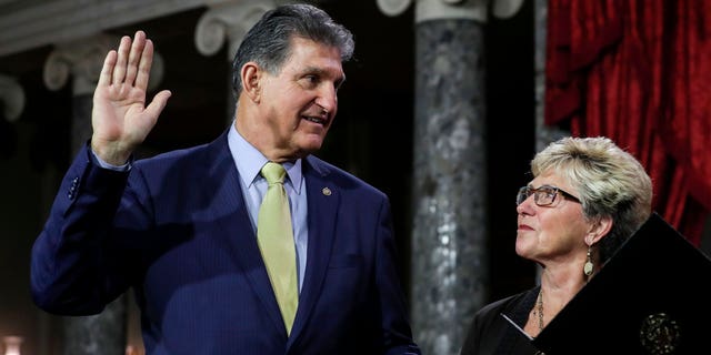 US Senator from West Virginia (D) Joe Manchin III is flanked his wife Gayle as he is sworn in by Vice President Mike Pence (out of frame) during the swearing-in re-enactments for recently elected senators in the Old Senate Chamber on Capitol Hill in Washington, DC January 3, 2019.