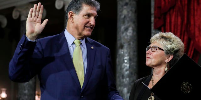 US Senator from West Virginia (D) Joe Manchin III is flanked his wife Gayle as he is sworn in by Vice President Mike Pence (out of frame) during the swearing-in re-enactments for recently elected senators in the Old Senate Chamber on Capitol Hill in Washington, DC January 3, 2019.