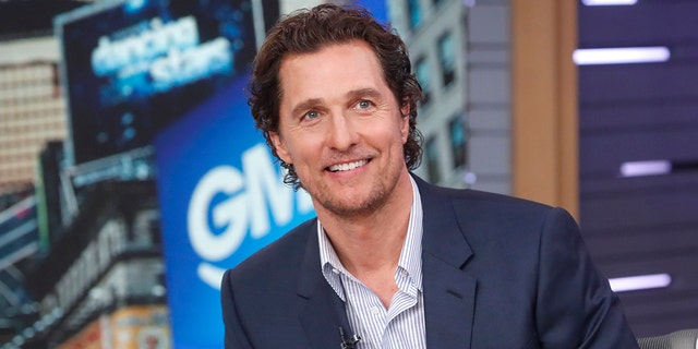 Matthew McConaughey in a blue striped shirt and navy blazer jacket smiles while on GMA