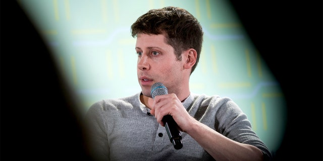 Sam Altman holding microphone 