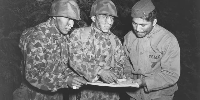 Private First Class Peter Nahaidinac, left, Private First Class Joseph Gatewood and Corporal Lloyd Oliver, right, all Navajo, study an issue at the Amphibious Scout School in June 1943.