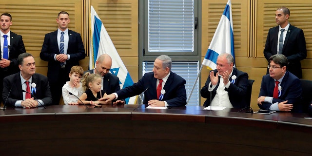 Perdana Menteri Israel Benjamin Netanyahu, tengah, di samping Menteri Kehakiman Amir Ohana, kiri-tengah, di Knesset di Yerusalem pada 3 Oktober 2019.