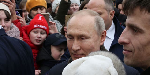 El presidente ruso, Vladimir Putin, abraza a un bebé que llora mientras saluda a los residentes en Ivanovo, Rusia, el 6 de marzo de 2020. (Mikhail Svetlov/Getty Images)