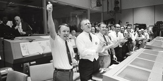 Apollo 13 - NASA, 1970. Mission Control Center, Houston, Texas: Three of the four Apollo 13 flight directors applaud the successful splashdown of the Command Module Odyssey, April  17, 1970. Artist NASA. 