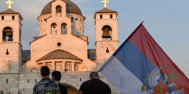 People attend a church-led protest in front of the Serbian Orthodox Church of Christ's Resurrection in Podgorica, on Aug. 23, 2020.