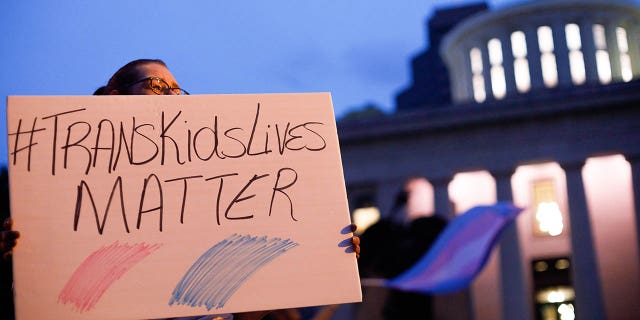 Transgender rights protester holds sign