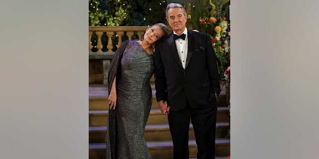 Melody Thomas Scott as Nikki Newman in a sparkly dress leans her head against Eric Braeden as Victor Newman in a classic black tuxedo in an episode of "The Young and the Restless"