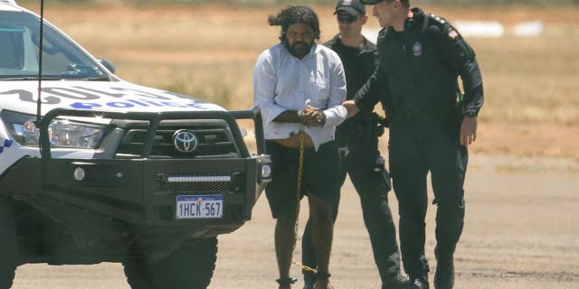 Terence Darrell Kelly, left, boards a plane after being taken into custody by members of the Special Operations Group at Carnarvon airport on Nov. 5, 2021 in Carnarvon, Australia.