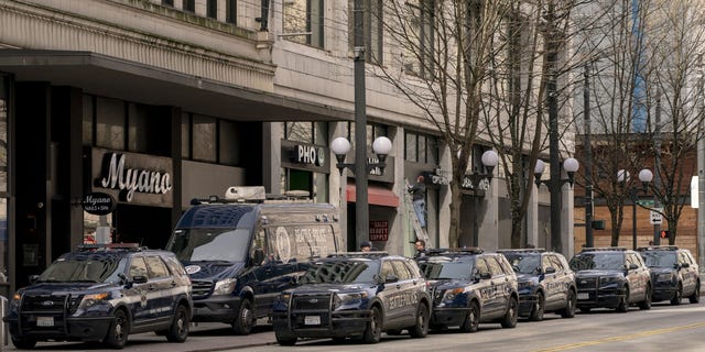 Seattle Police Department vehicles surround a mobile precinct unit on Third Avenue in downtown Seattle March 24, 2022.