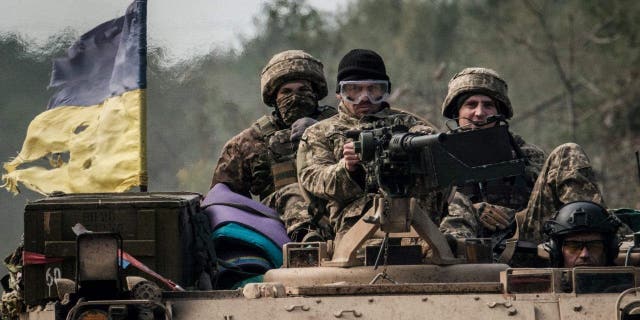 Ukrainian soldiers ride on an armored vehicle near the retaken town of Lyman in Donetsk region Oct. 6, 2022, amid the Russian invasion of Ukraine.