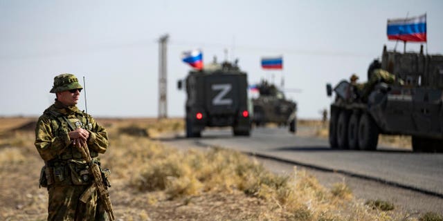 Soldiers of a Russian military convoy and their U.S. counterparts exchange greetings as their patrol routes intersect in an oil field near Syria's al-Qahtaniyah town in the northeastern Hasakah province, close to the border with Turkey, on October 8, 2022.
