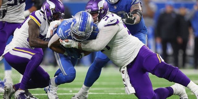 El receptor abierto de los Detroit Lions, Amon-Ra St. Brown, #14, es abordado por el tackle defensivo de los Minnesota Vikings, Harrison Phillips, #97, durante la segunda mitad de un partido de fútbol americano de la NFL en Detroit, Michigan, EE. UU., el domingo 11 de diciembre de 2022.