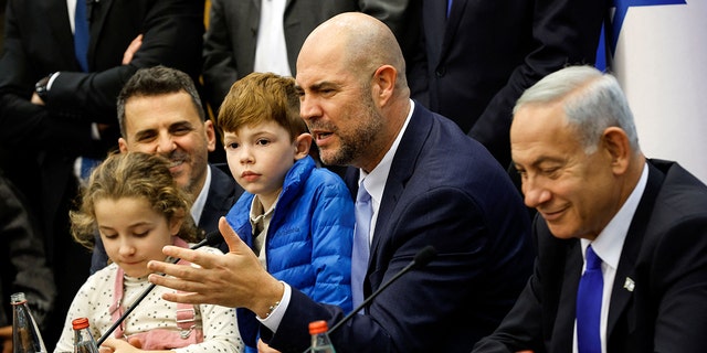 New Israeli Knesset speaker Amir Ohana, center, speaks next to newly-sworn Prime Minister Benjamin Netanyahu, right, at the Knesset in Jerusalem on December 29, 2022. 