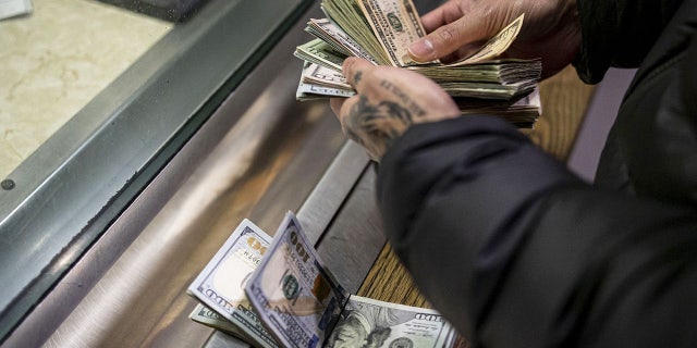 A man pays cash bail in the bond office to secure his brothers release on Dec. 21, 2022, at Division 5 of the Cook County Jail.