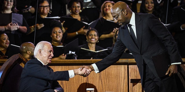 Sen. Raphael Warnock greets President Joe Biden during a worship service in Atlanta, Georgia, on Jan. 15, 2023, ahead of Martin Luther King, Jr. Day. Despite Warnock's win in Georgia, the DNC opted to host the 2024 convention in Illinois.