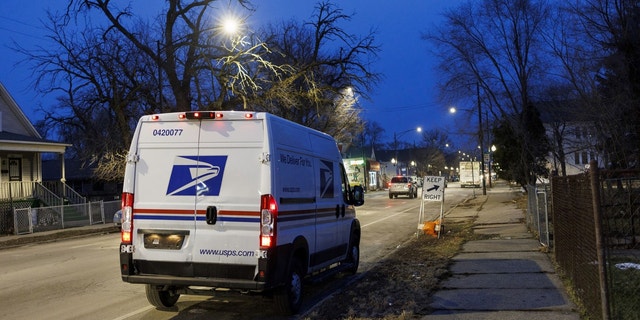 A United States Postal Service van sits in the West Pullman neighborhood of Chicago after sunset on Feb. 8, 2023.
