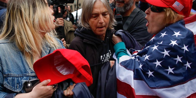 Protesters argue amid the chaotic scene outside the Manhattan courthouse where Trump is expected to be arraigned Tuesday.