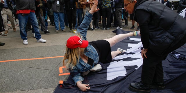 The Trump supporter falls to the ground on the anti-Trump banner.
