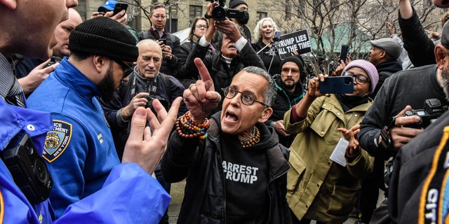 A protester yells at a New York City police officer outside the court.