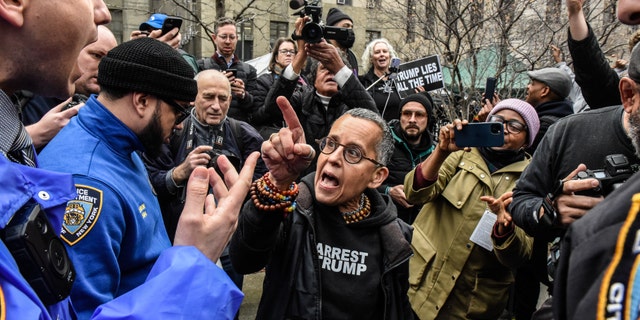 A protester yells at a New York City police officer outside the court.