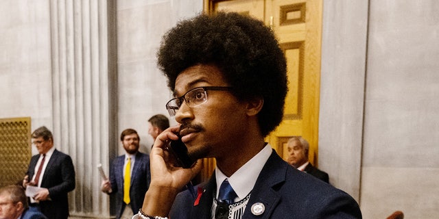 Democratic state Rep. Justin Pearson of Memphis speaks on his phone while being expelled from the state legislature April 6, 2023, in Nashville.