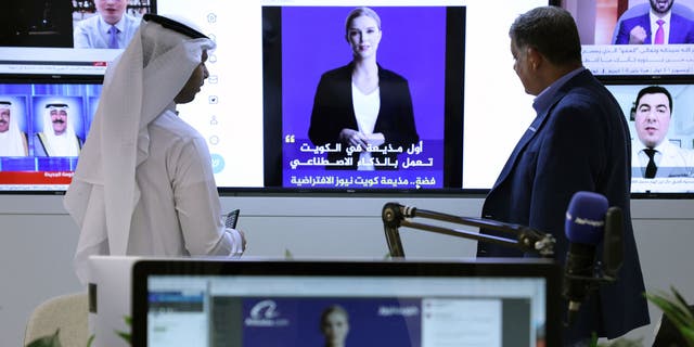 Reporters watch an AI-generated news anchor named "Fedha," which the Kuwait News service recently debuted.