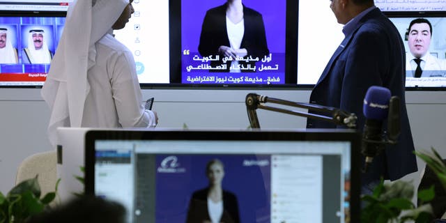 Reporters watch an AI-generated news anchor named "Fedha," which the Kuwait News service recently debuted.