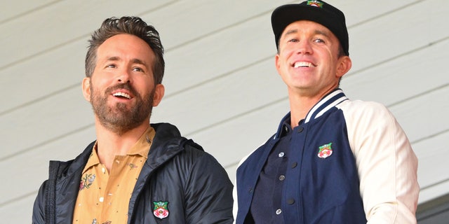 Ryan Reynolds and Rob McElhenney watch a soccer game from the stands