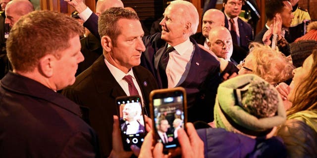 President Biden takes a selfie picture with a mobile phone as he greets members of the public as he leaves the Windsor Bar in Dundalk, on April 12, 2023, as part of a four-day trip to Northern Ireland and Ireland for the 25th anniversary commemorations of the "Good Friday Agreement."