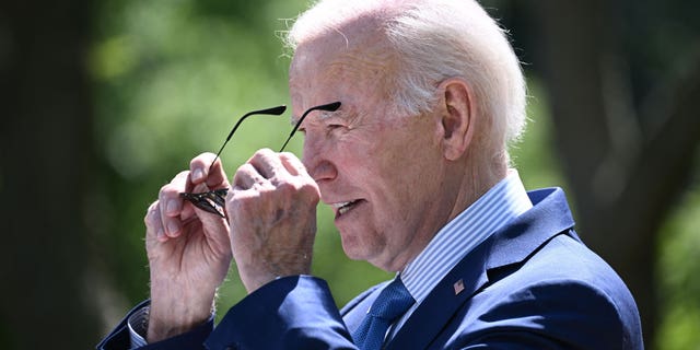 President Joe Biden putting on sunglasses