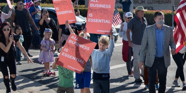 Orange County Supervisor Don Wagner, right, joins a group of protesters