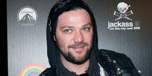Bam Margera in a black hoody looks off in distance