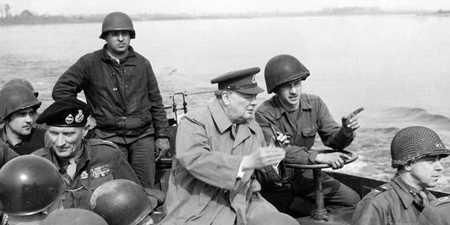 British Prime Minister Winston Churchill traveling with American GIs on a U.S. landing craft on the Rhine River with British Marshal Bernard Law Montgomery, U.S. General William Hood Simpson and U.S. General William Shaffer Key, March 25, 1945. 