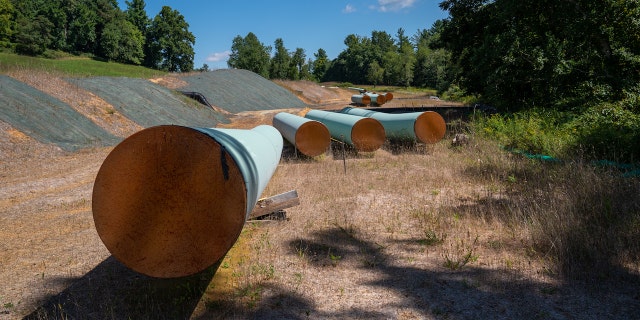 BENT MOUNTAIN, VIRGINIA - AUGUST 31: Sections of 42 diameter sections of steel pipe of the Mountain Valley Pipeline, MVP, lie on wooden blocks, August 31, 2022 in Bent Mountain, Virginia.  The MVP will transport natural gas through 303 miles of West Virginia and Virginia.  Public opposition has centered on challenging MVPs permitting through wetlands and national forests.  The original budget of $3.5 billion is now estimated to be $6.2 billion.  The Federal Energy Regulatory Control agency, FERC, has recently granted MVP another 4-years to complete.  (Photo by Robert Nickelsberg/Getty Images)