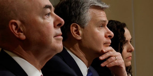 Christopher Wray, center, at congressional hearing, with Alejandro Mayorkas at left