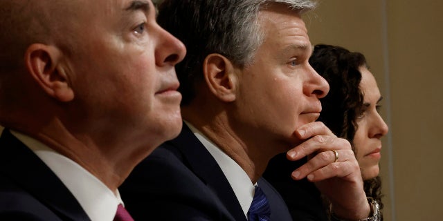 Christopher Wray, center, at congressional hearing, with Alejandro Mayorkas at left