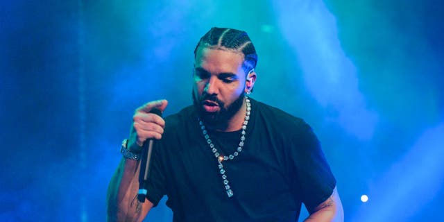 Drake wears a black shirt and performs on stage in Atlanta