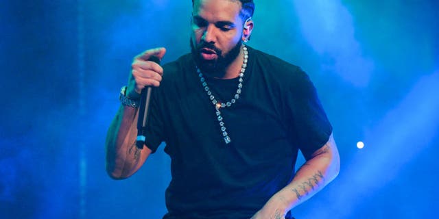 Drake wears a black shirt and performs on stage in Atlanta